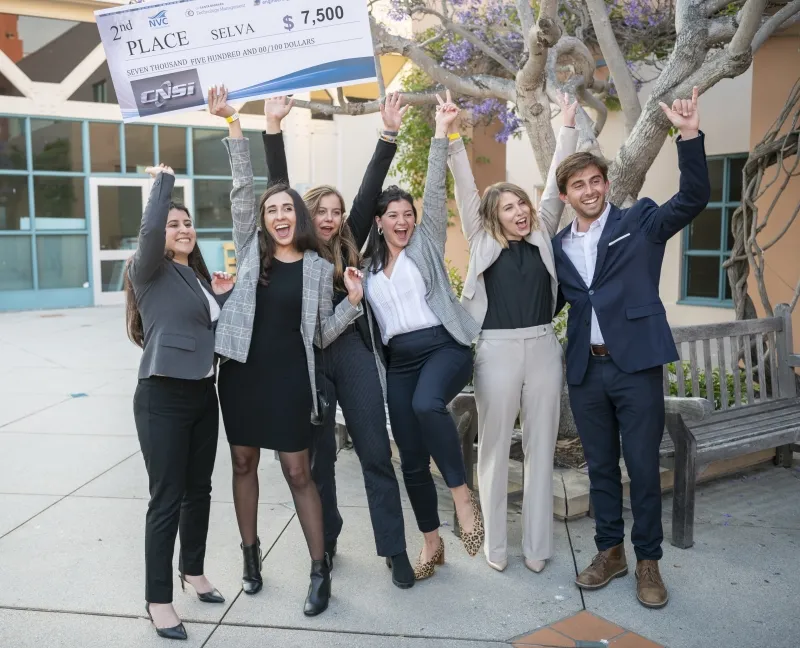 Group of elated students holding a large prize check 