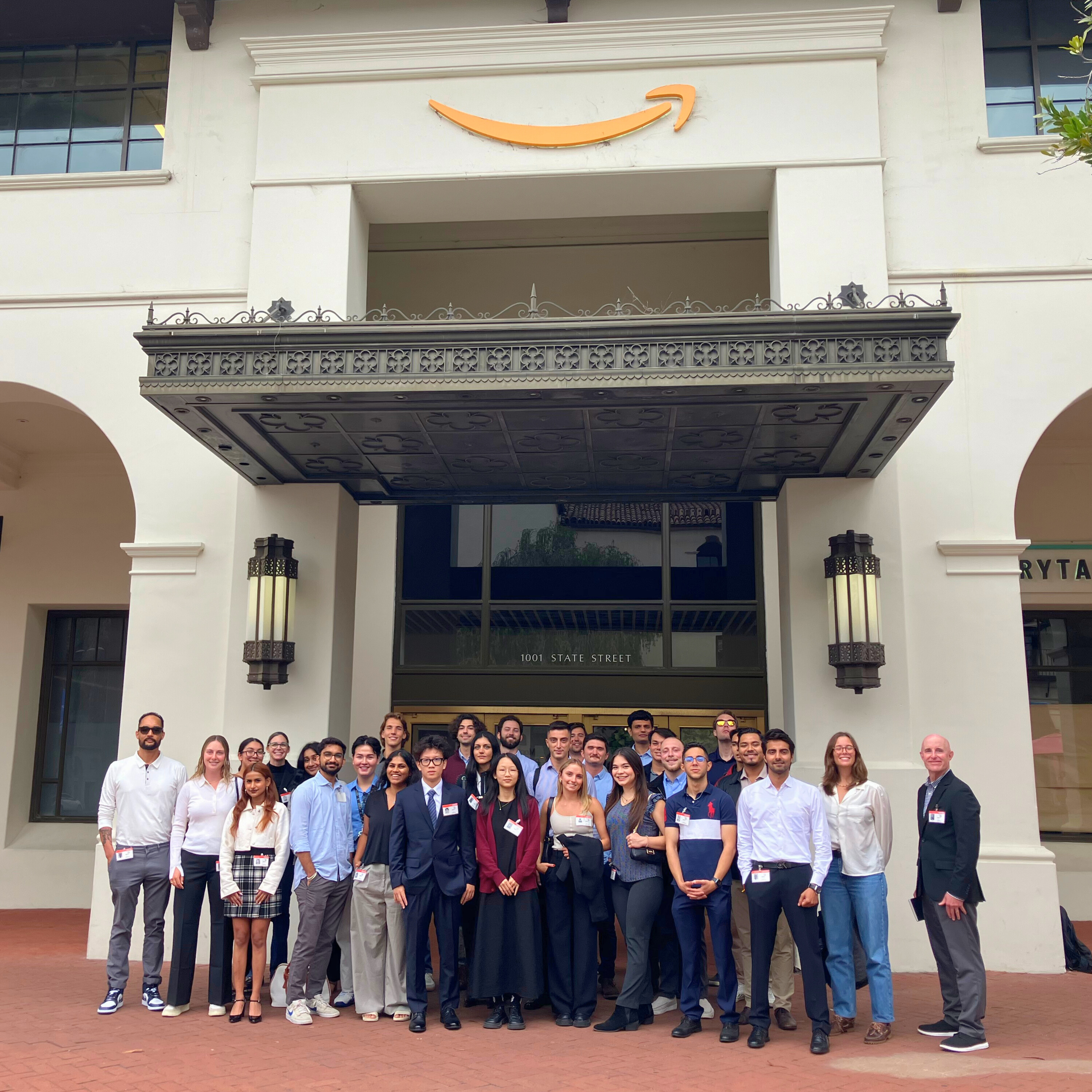 A group of students and faculty standing in front of an Amazon building.