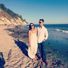 chad posing with a woman on the beach