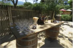 photo of a wooden table with wine glasses on top of it