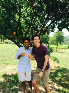 Sangodkar and a companion laughing underneath a fruit tree