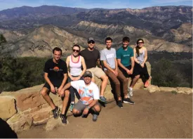 photo of the seven students sitting on a cliff