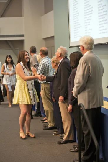 students shake hands with faculty and staff