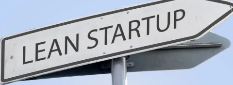 white street sign that reads "lean startup". it points off to the right