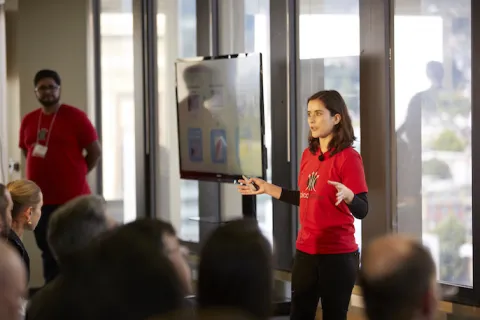 a female student presents in front of a group of people