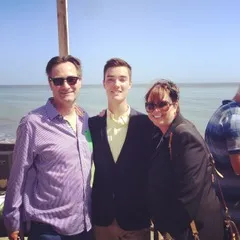 photo of Chad Gledhill with his parents standing in front of a beach