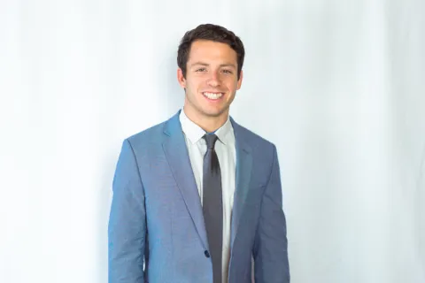 photo of Matt Turner in a suit with a white backdrop