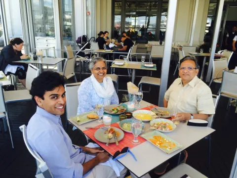 student Rahul Sangodkar eats a meal with his family