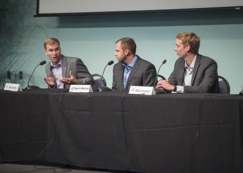 three gentlemen speaking at a panel