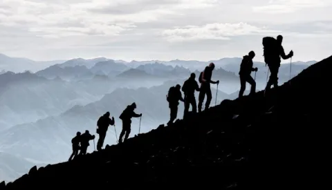 photo of a group of hikers hiking up a mountain