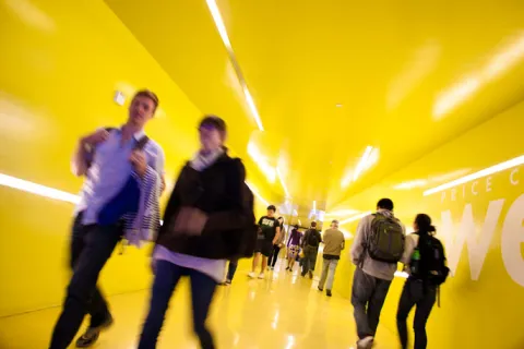 photo of a long yellow hallway filled with students