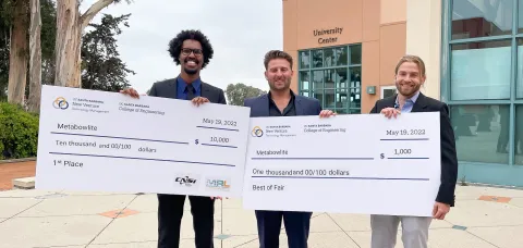 Entrepreneurs pose with large check displays indicating $10,000 and $1,000 in award money.