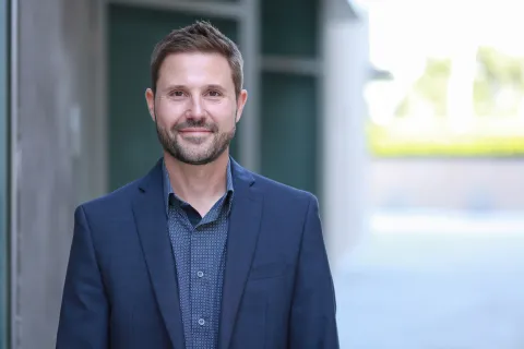 Professor Paul Leonardi wearing a dark blue suit in front of a building. 